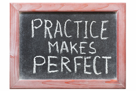 practice makes perfect phrase handwritten on vintage blackboardの写真素材