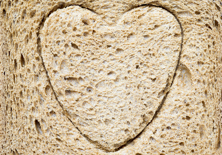 detailed surface of brown bread slice with embossed  heart symbolの写真素材