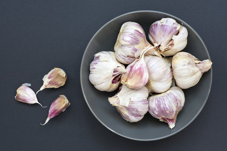 gray bowl full of garlic on dark gray backgroundの写真素材