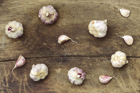 many garlic cloves and bunches on vintage wooden tableの写真素材