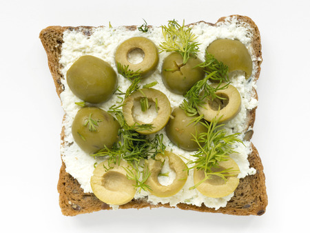 toast with soft cheese, pitted olives and fennel isolated on whiteの写真素材