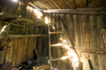 old wooden abandoned barn interior with bright sun beams