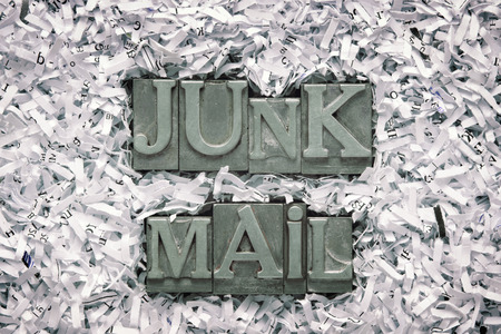 junk mail phrase made from metallic letterpress type inside of shredded paper heapの写真素材