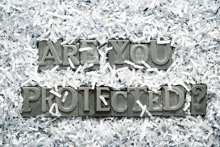 are you protected question made from metallic letterpress type inside of shredded paper heapの写真素材