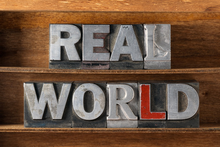 real world phrase made from metallic letterpress type on wooden trayの写真素材