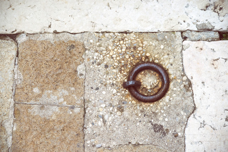 rusty ring embedded into ancient pavement for boats locking in Venice, Italyの写真素材