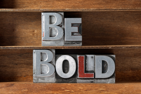 be bold phrase made from metallic letterpress type on wooden trayの写真素材
