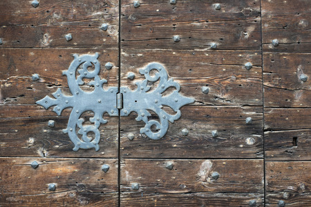 ornamental rustic hinge of ancient wooden door in Venice, Italyの写真素材