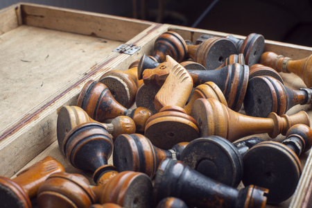 open vintage box full of old wooden chess pieces