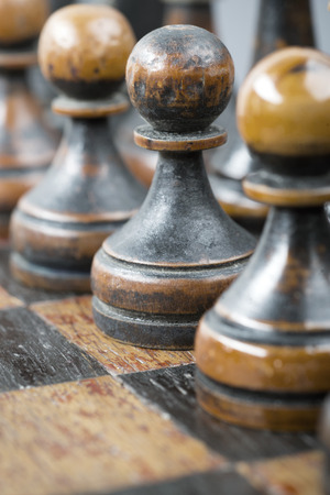 black chess pawns row with focus on central pieceの写真素材