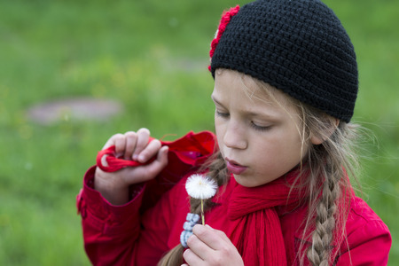 girl blowing white dandelion outdoorの写真素材