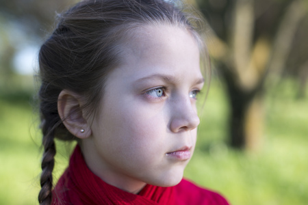 serious girl portrait with big trees outdoorの写真素材