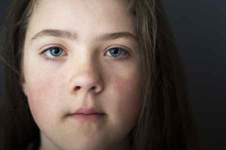closeup portrait of teenage girl with dark background