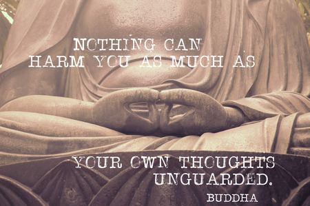Nothing can harm you as much - famous Buddha quote printed on image of sculpture's hands in peaceful positionの写真素材