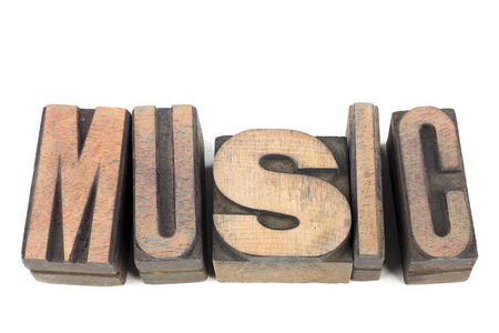 music word made from scattered wooden letterpress blocks isolated on whiteの写真素材