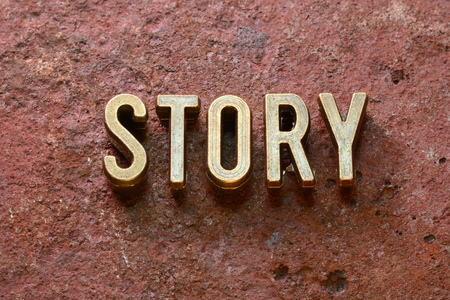 story word made from metallic letters on red rusty surfaceの写真素材