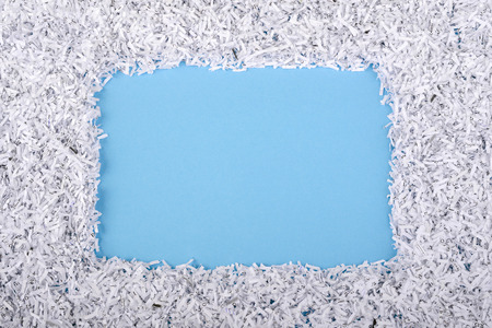 blue background with shredded paper frame aroundの写真素材