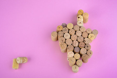 bunch of grapes made from many wine corks on pink backgroundの写真素材