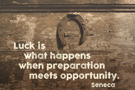 famous ancient Roman philosopher quote printed on vintage wooden door with hanged rusty horseshoe...