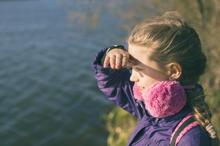 child girl on the shore looking far away by springtimeの写真素材