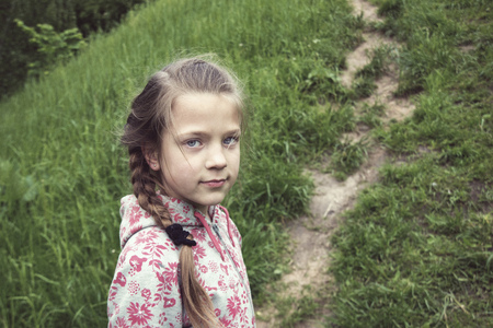 child girl look back on the outdoor pathwayの写真素材