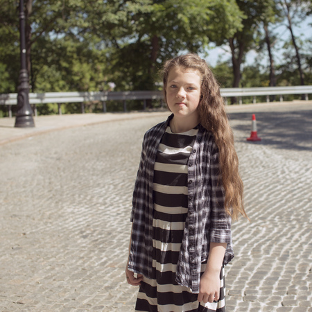 teenage girl portrait standing on cobblestone streetの写真素材