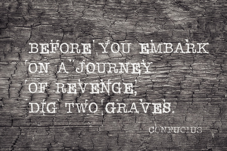 Before you embark on a journey of revenge, dig two graves - ancient Chinese philosopher Confucius quote printed on burned wood boardの写真素材