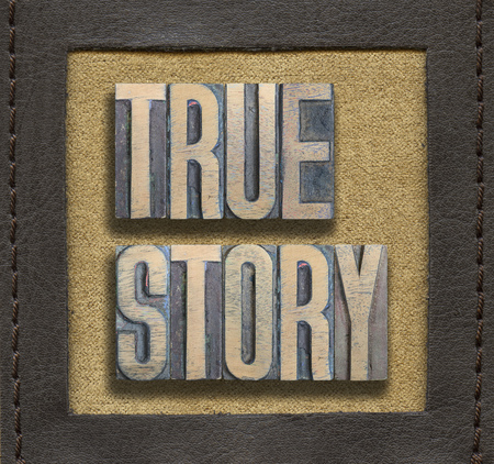 true Story phrase assembled from vintage wooden letterpress inside stitched leather frameの写真素材