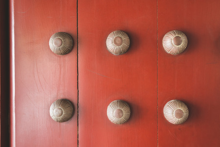 red door background with massive metallic handles of Buddhist temple in Singaporeの写真素材