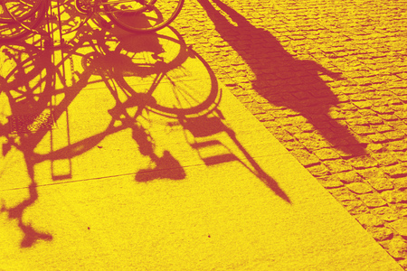 bright background of Milan city pavement with shadows of bicycles and people