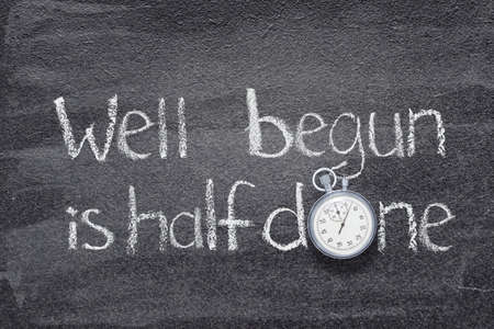 well begun is half done proverb  written on chalkboard with vintage stopwatch instead of Oの写真素材