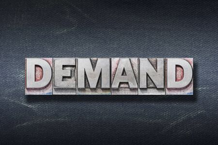 demand word made from metallic letterpress on dark jeans backgroundの写真素材