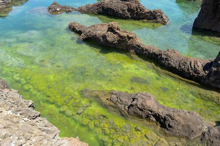 shallow sea water pond in natural rocks from Porto-Moniz, Portugal