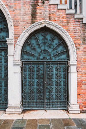 vintage forged gate under building stairs in Venice, Italyの写真素材