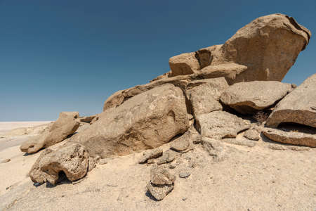 ancient weathered desert rocks by hot day in Namibiaの写真素材