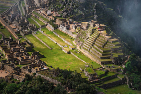 aerial view through scattered clouds to Machu Picchu ruins by early morningの写真素材
