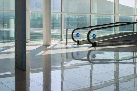 light airport hall with wide windows and empty travelator