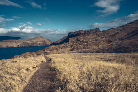 wild mountain landscape of Madeira Island with hiking trail leading far awayの写真素材