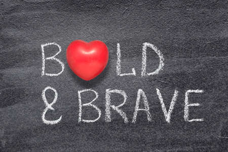 bold and brave phrase written on chalkboard with red heart symbolの写真素材