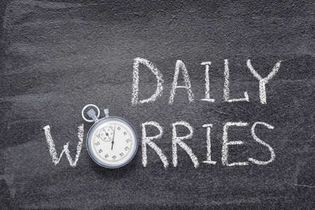 daily worries phrase written on chalkboard with vintage stopwatch used instead of Oの写真素材
