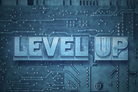 level up phrase made from metallic letterpress blocks on the pc board backgroundの写真素材
