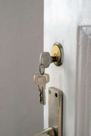 fragment of open door with keys inside keyholeの写真素材