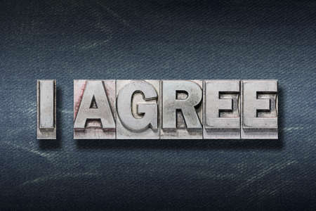 I agree phrase made from metallic letterpress on dark jeans backgroundの写真素材
