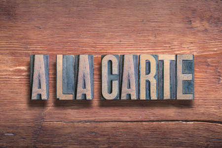 a la carte, commonly used French phrase meaning - on the card, on the menu, combined on vintage varnished wooden surfaceの写真素材
