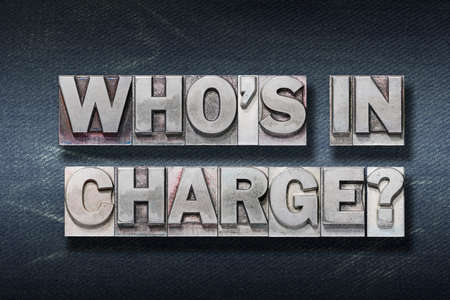 who is in charge question made from metallic letterpress on dark jeans backgroundの写真素材