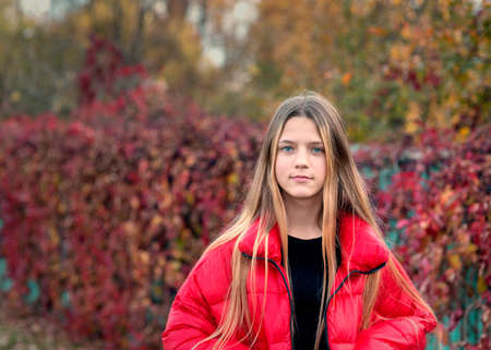 teenage girl in red jacket outdoors portrait by fall