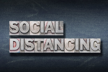 social distancing phrase made from metallic letterpress on dark jeans backgroundの写真素材