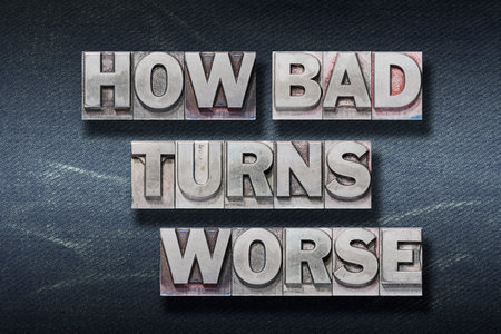 how bad turns worse phrase made from metallic letterpress on dark jeans backgroundの写真素材