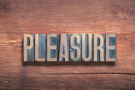 pleasure word combined on vintage varnished wooden surfaceの写真素材