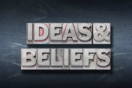 ideas and beliefs phrase made from metallic letterpress on dark jeans backgroundの写真素材